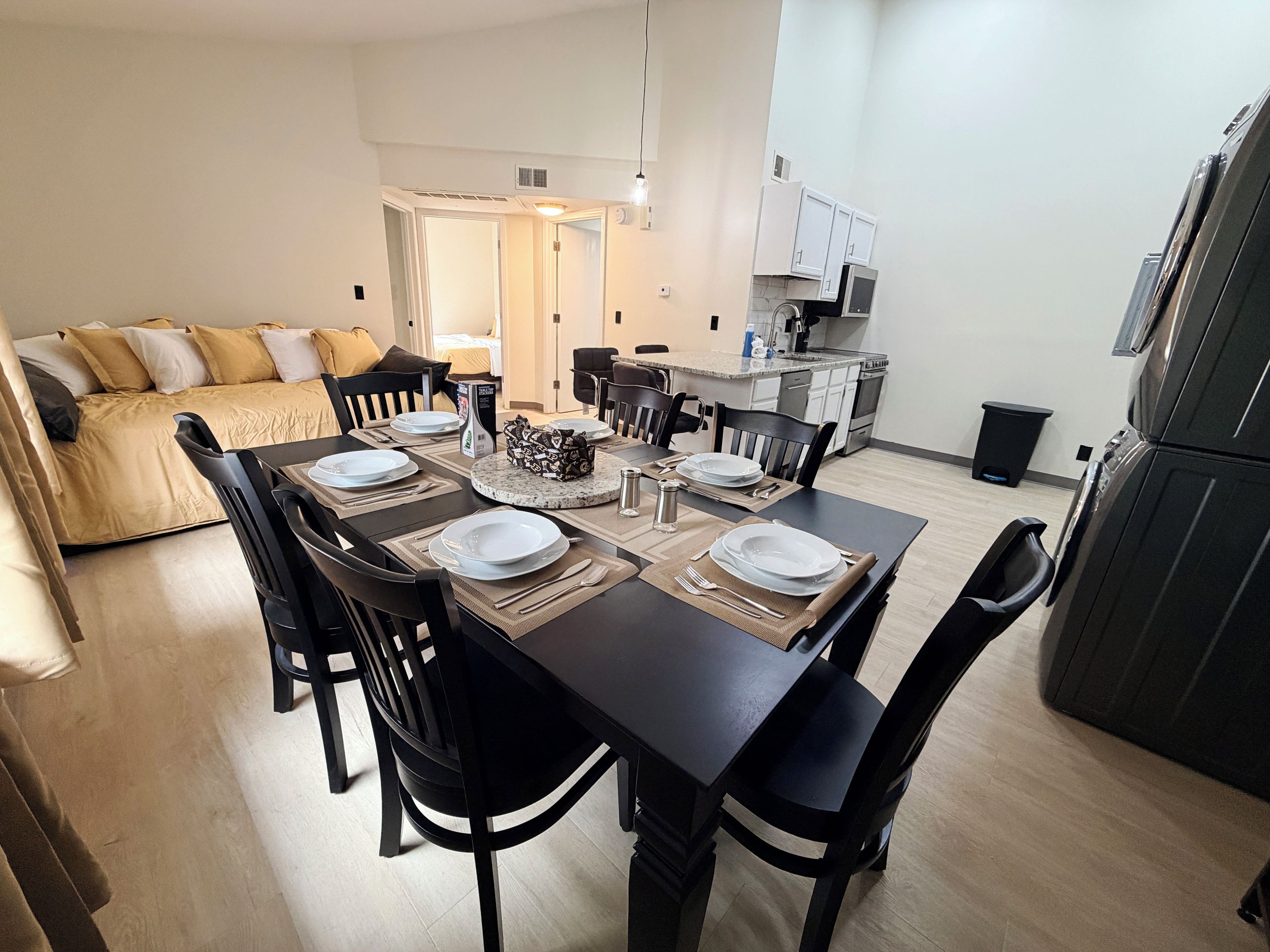 Un apartamento moderno con comedor, kitchenette y sala de estar con sofá.