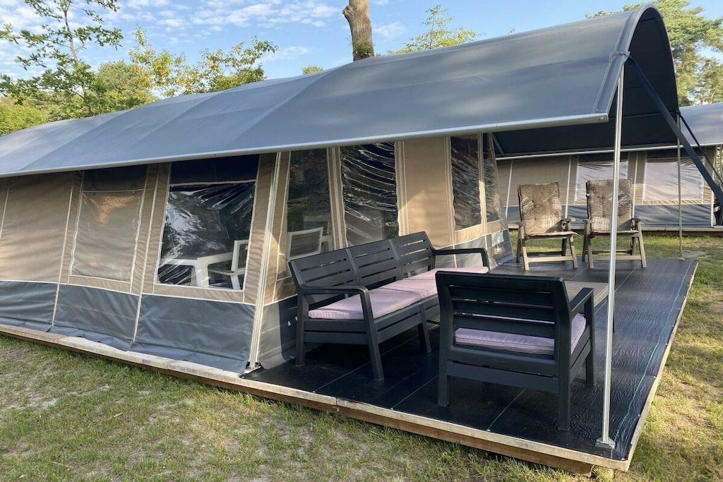 A portable tent with a patio area, including a table and chairs.