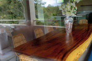 Ein Holztisch mit einer Mosaikvase, die weiße Blumen enthält.