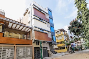 Un edifici residencial de diverses plantes amb un disseny modern, amb balcons i una combinació de materials a la façana.
