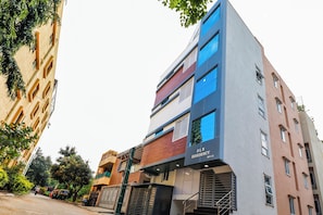 Un edifici de diverses plantes amb façana moderna, una escala visible i un senyal que indica que és una residència.