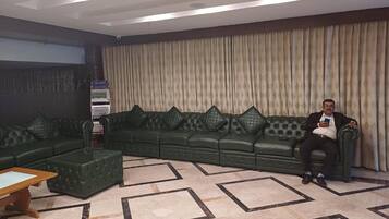 Un salon avec un canapé d’angle, une table basse et un tapis à motifs.