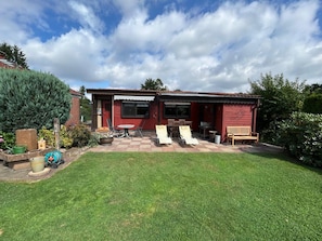 A red house with a patio, a lawn, and a large tree. - At the Broom Bush (Wettringen)
