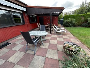 A patio with a checkered floor, a round table, and four chairs. - At the Broom Bush (Wettringen)