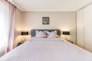 Ein Schlafzimmer mit einem Bett, zwei Nachttischen, einem Kopfteil und einem Wandbild.