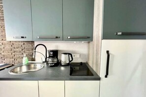Eine Küche mit Spüle, einer Kaffeemaschine und Schränken.