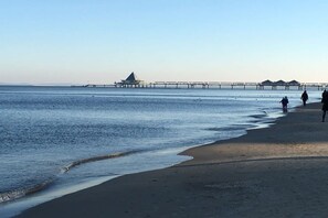 A beach with a pier extending into the water, people walking along the shore, and a clear sky. - Holiday home with 3 bedrooms (Heringsdorf)
