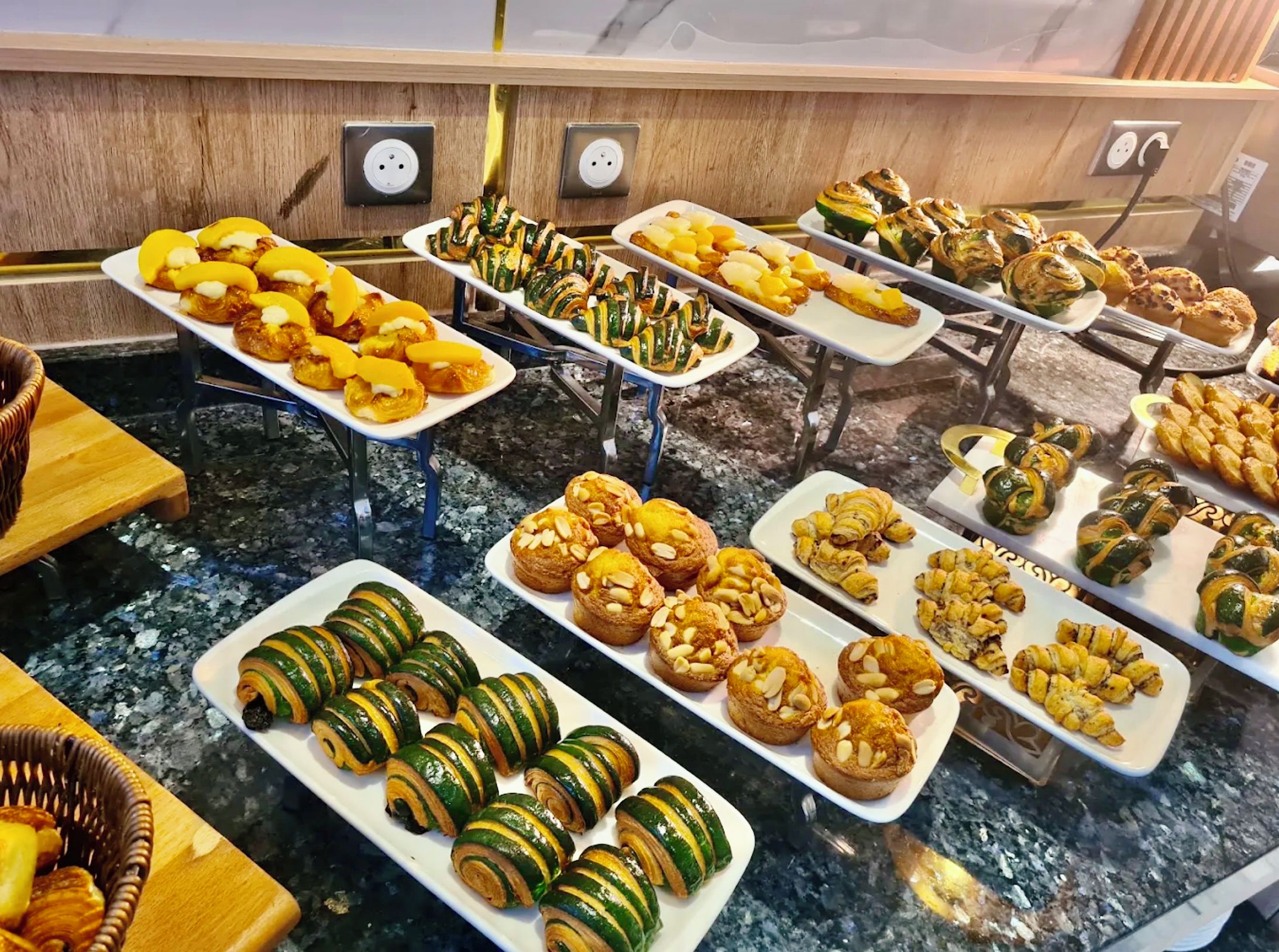 A buffet with various pastries and baked goods.