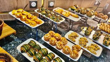 A buffet with various pastries and baked goods.