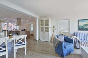 A spacious living area with a dining table, chairs, a sofa, and a cabinet. - Holiday apartment with 2 bedrooms (Breege)