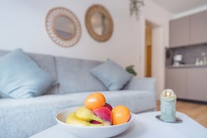 A bowl of fruit on a table with a sofa and a mirror in the background. - Hi there, and welcome to the Küstenkoje! (Dangast)