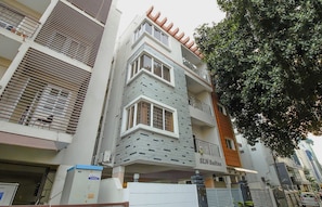 A multi-story building with a modern architectural design, featuring a prominent entrance with a sign that reads 'SLN Suites.'