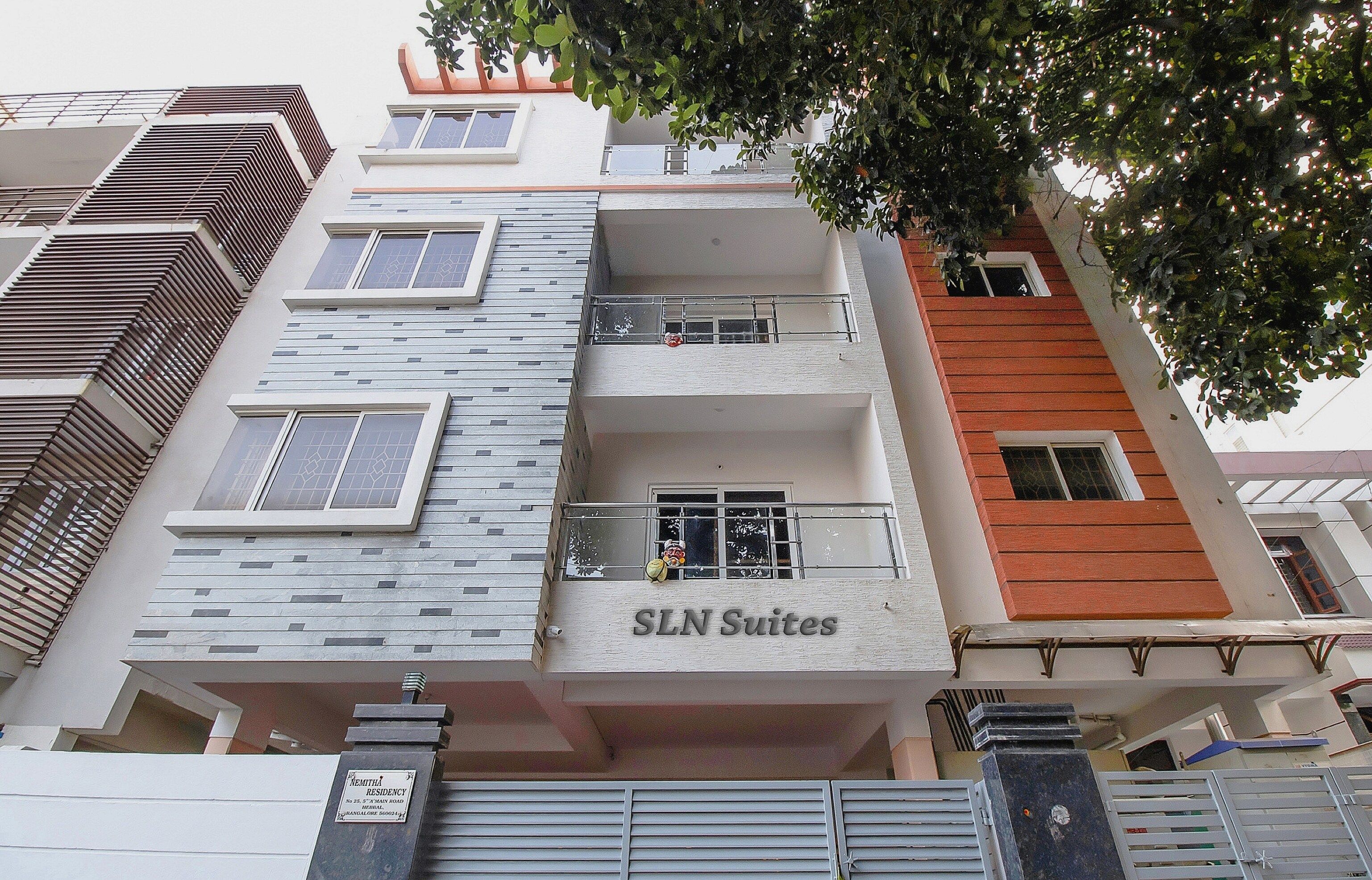 A multi-story building with balconies and a sign reading 'SLN Suites'.
