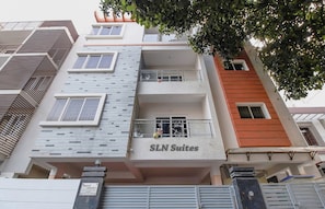 Un edifici de diverses plantes amb balcons i un rètol que diu 'SLN Suites'.