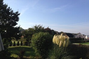A residential area with a well-maintained lawn, a large tree, and a house in the background. - Holiday home with 3 bedrooms (Altenkirchen)