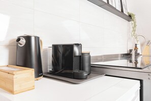 A modern kitchen with a coffee maker, a water dispenser, and a wooden box on the counter. - Mc'Maggies Atelier – Stylish Vacation Rental with a Hot Tub Near Düsseldorf (Meerbusch)