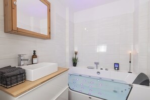 A modern bathroom with a white sink, a glass-enclosed bathtub, and a wooden vanity. - Mc'Maggies Atelier – Stylish Vacation Rental with a Hot Tub Near Düsseldorf (Meerbusch)