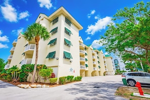 A multi-story hotel with balconies, a palm tree, and a red fire hydrant. - 2BR Key West condo with pool, hot tub, kitchen, WiFi (Key West)
