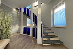 A staircase with blue railings and a window with blinds. - Holidays in a Lighthouse (Glowe)