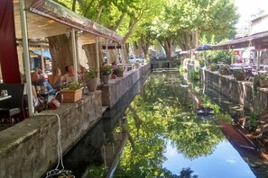 A canal-side restaurant with outdoor seating, a waterway, and trees. - Holiday home with 4 bedrooms (SAINT MICHEL D'EUZET)