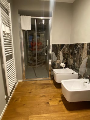 A bathroom with a glass shower door, a white toilet, and a white sink. - Residenza dei Cerchi ***** In the heart of the historic center Everything is just a short walk away (Firenze)