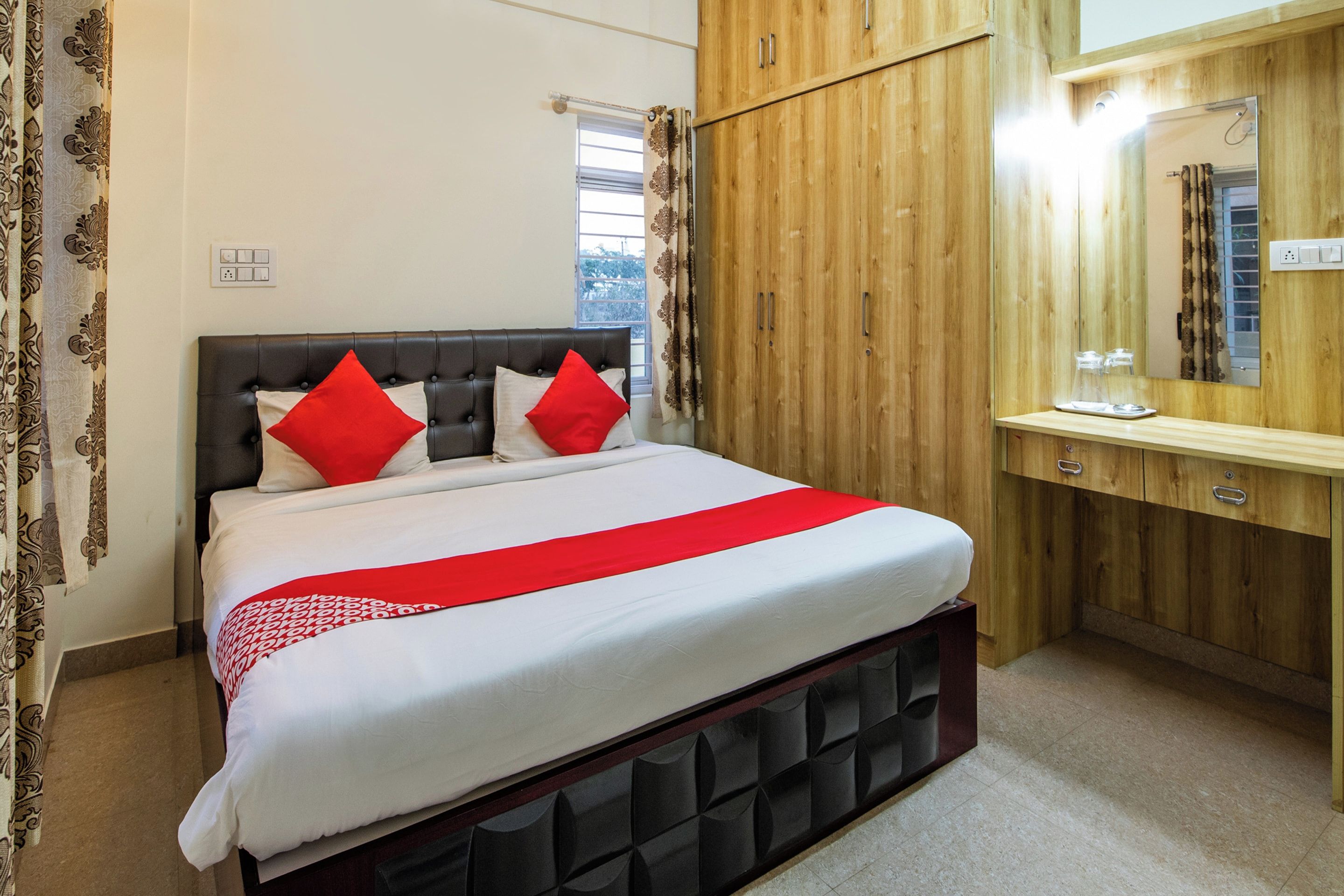 Un dormitorio con cama, armario de madera y espejo.