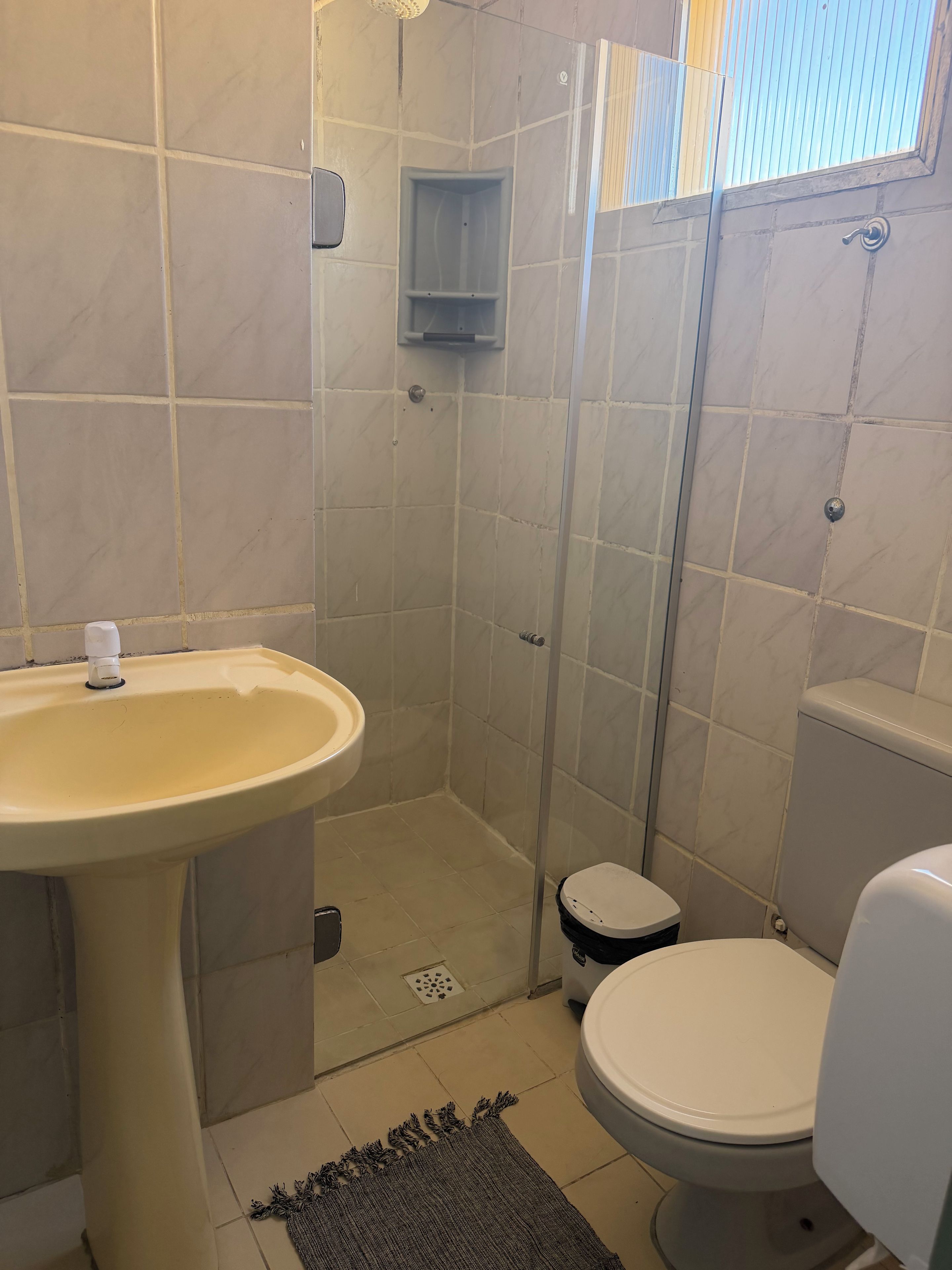 A bathroom with a sink, toilet, and shower stall.
