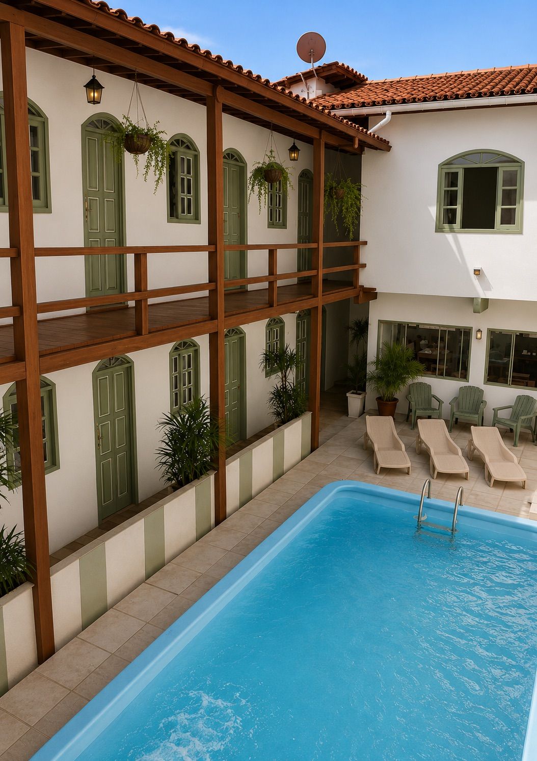 A poolside area with a pool, lounge chairs, and a building with multiple windows and doors.