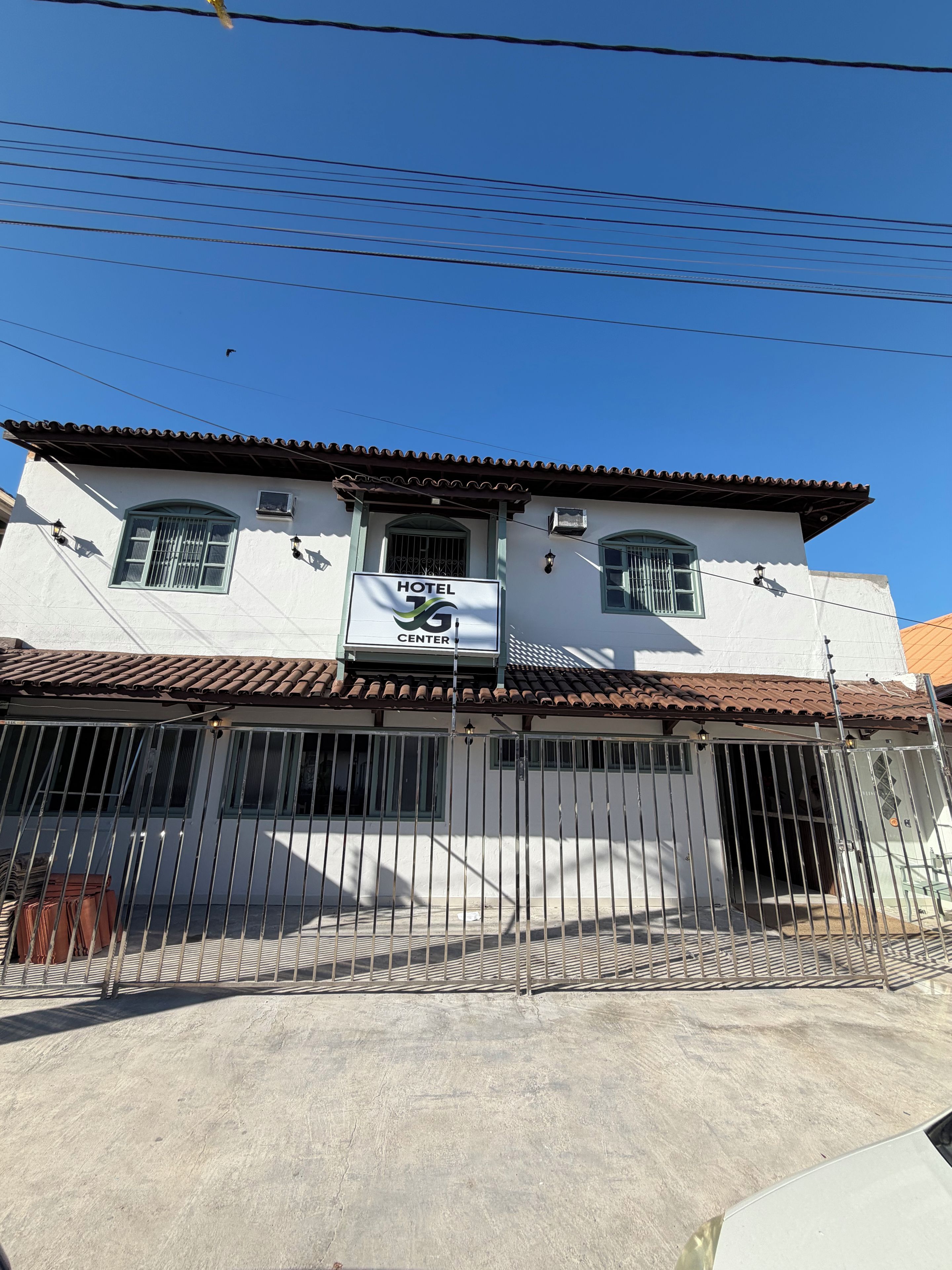 A hotel with a tiled roof, a gated entrance, and a sign indicating it is a hotel center.