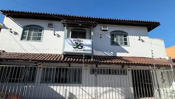 A hotel with a tiled roof, a gated entrance, and a sign indicating it is a hotel center.