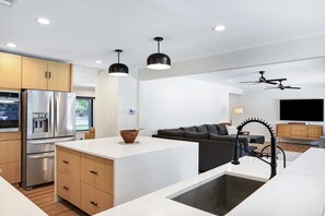 A modern kitchen with a central island, built-in appliances, and pendant lighting. - Huge 3BR Home w/ Pool & Modern Interior (San Antonio)