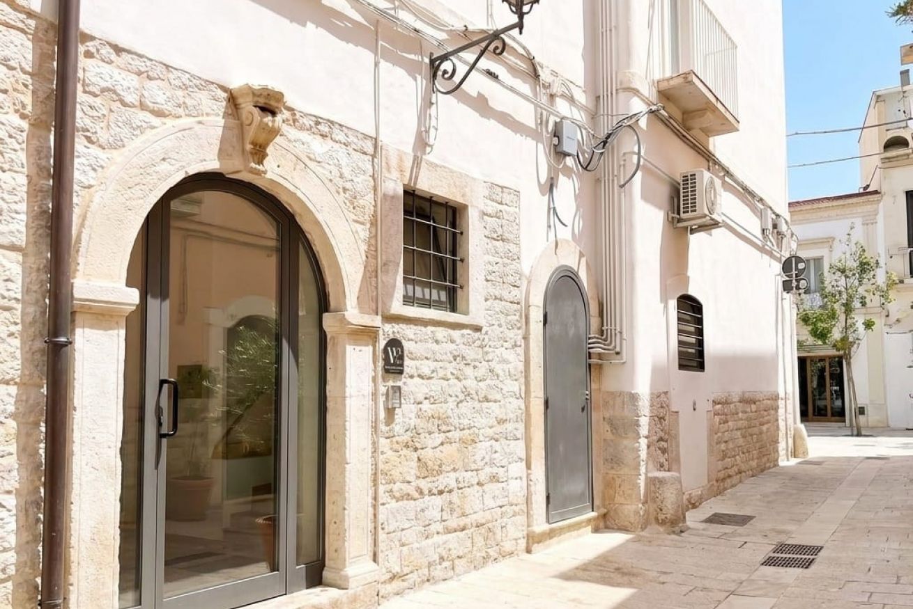 Un bâtiment doté d’une façade en pierre, d’une grande entrée en arc de cercle et d’une petite fenêtre.