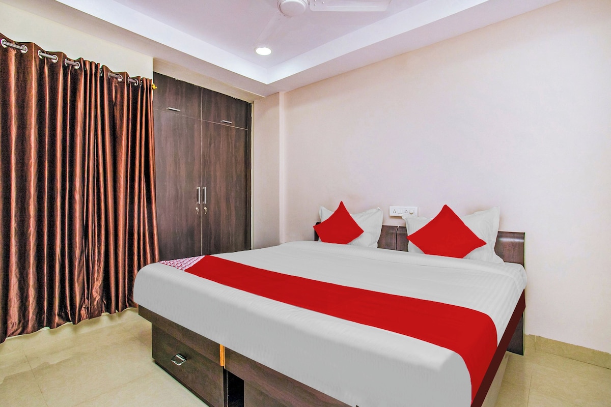 Una habitación de hotel con cama, armario y ventilador de techo.