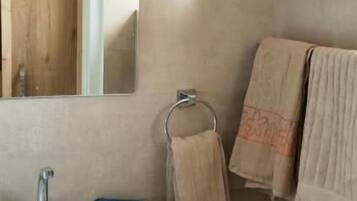 Un baño con lavamanos, espejo y toallas.