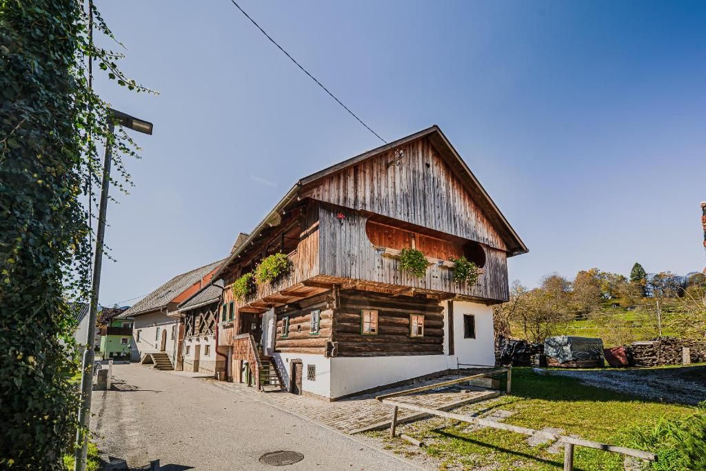 Un edificio tradicional de madera con techo inclinado, un porche delantero y una escalera que conduce a la entrada.