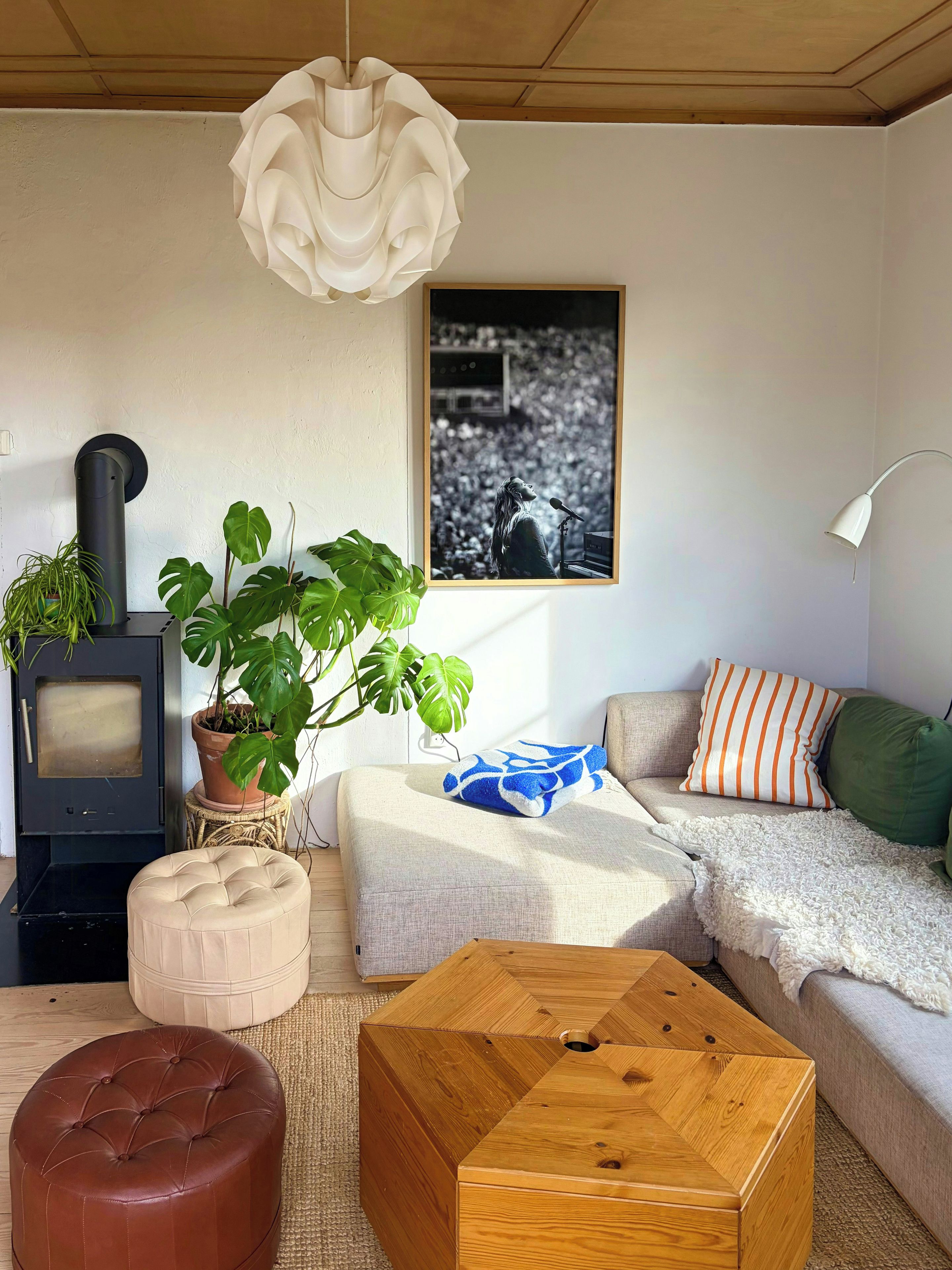 A living room with a fireplace, a sofa, a coffee table, and a hanging light fixture.