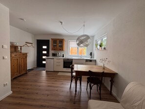 A kitchen with a wooden table, chairs, and a window. - Rental: Doktorberg 20.5 (Berchtesgaden)