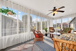A sunroom with large windows, wicker furniture, a ceiling fan, and a view of the outside. - Golfer's Lounge - 3/2 w/ 4-Seat Golf Cart in The Villages - De Le Vista (De La Vista, The Villages)