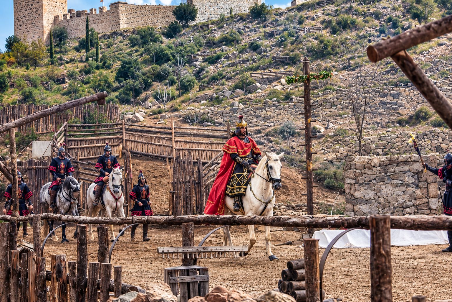 A medieval reenactment with mounted knights and a castle in the background.