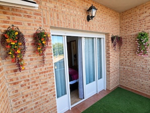 A brick exterior with a sliding glass door leading to a room.