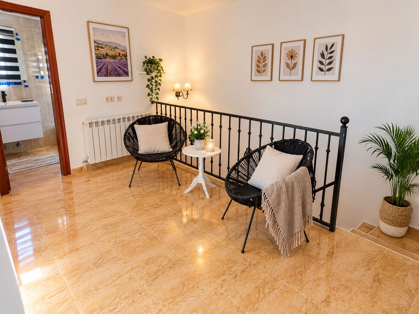 A modern living room with two black wicker chairs, a small round table, and a potted plant.