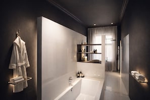 Et moderne badeværelse med et badekar, hylder med toiletartikler og et strygejern.