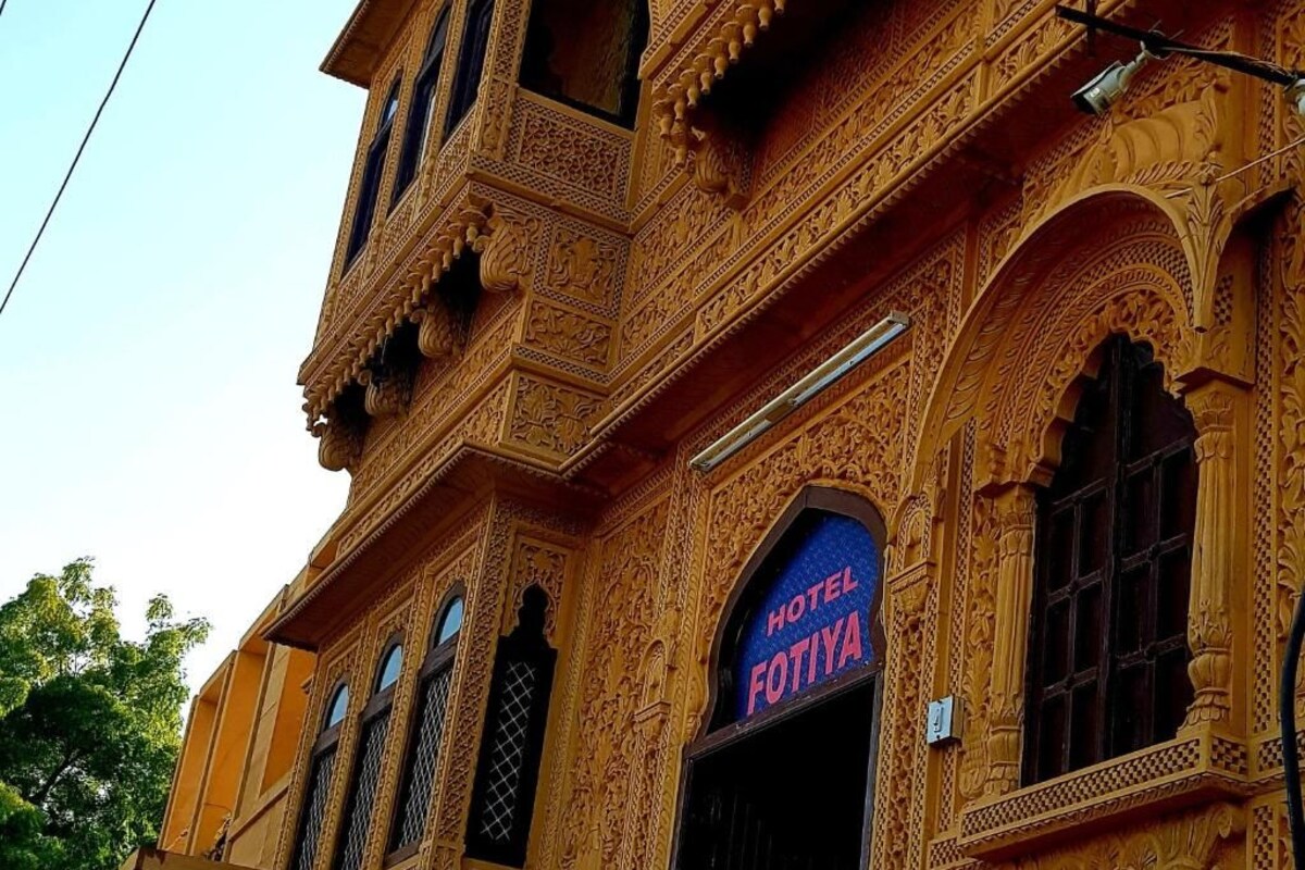 Ein Gebäude mit aufwendigen Schnitzereien und einem Schild mit der Aufschrift 'HOTEL FOTIYA'.
