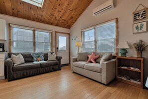 A spacious living room with two sofas, a coffee table, and a bookshelf.