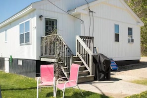 A small, single-story building with a porch and a staircase leading to a door marked with the number 2.