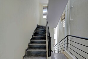 Una escalera con barandilla y un ventanal en la parte superior.