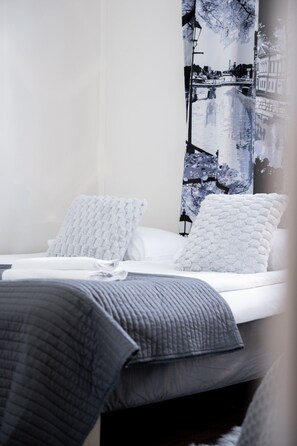 A bed with white linens and two pillows, a grey blanket, and a wall with a cityscape artwork. - City Centre Home, Sauna & Parking By Lapland Host (Rovaniemi)
