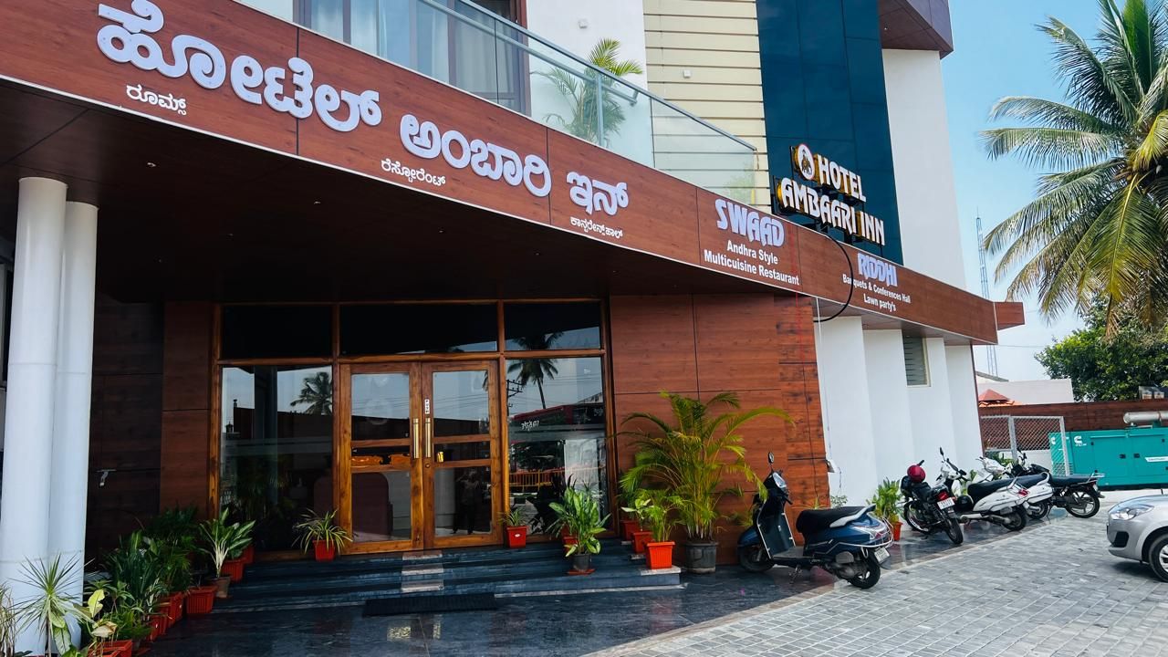 A hotel entrance with a modern design, featuring a glass facade and a wooden entrance.