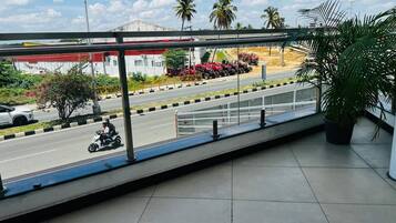 Un balcón con vista a una carretera, una motocicleta estacionada y una fila de tractores rojos.