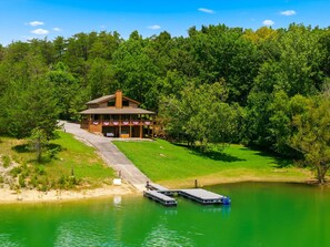 A lodge with a covered porch, a dock, and a lake. - Mountain Grace Lake Retreat (Sevierville)